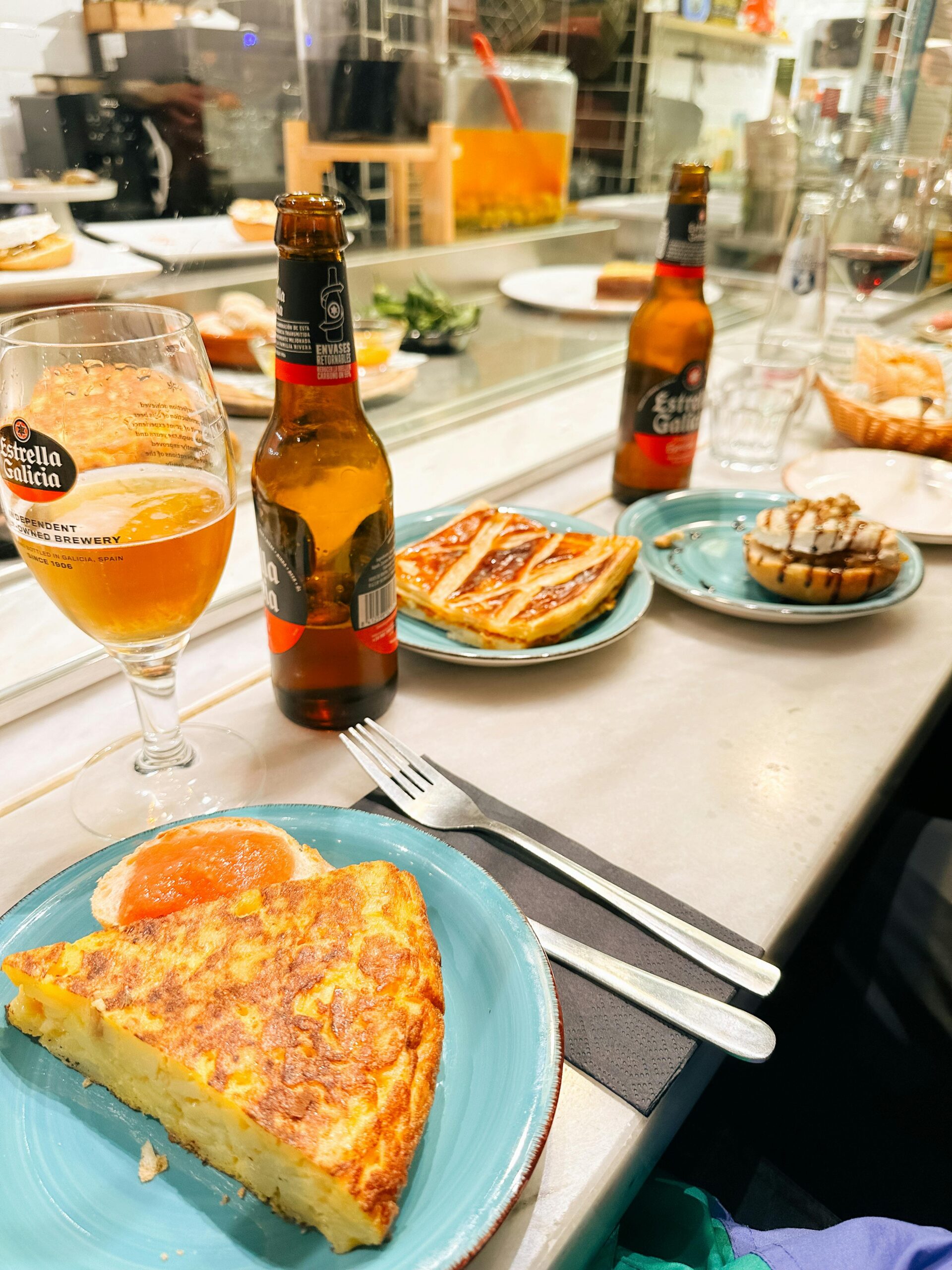 Close-up of traditional Spanish tapas with beer in a Berlin restaurant setting.